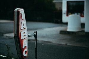 a red and white tabac signage with snow